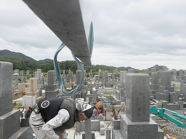 ユニック車のクレーンで巻石を吊り上げている写真