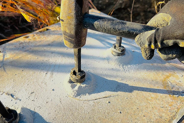 セリ矢を使用し、墓石を解体している写真