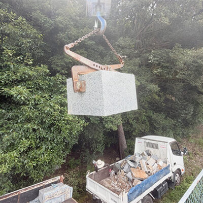 兵庫県 満願寺霊園で墓石の上台をクレーンで吊っている写真