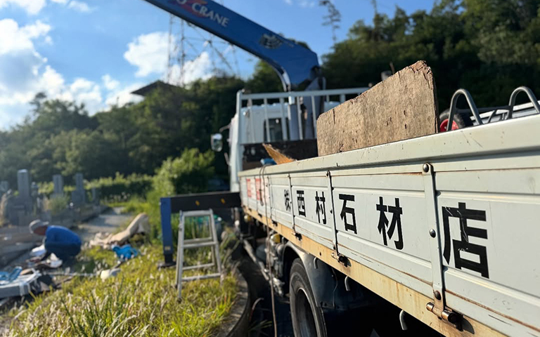 墓石工事用のトラックから庵治石の墓石を設置している風景