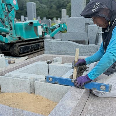 兵庫県宝塚市の霊園で、中国産御影石G６６３の巻石を据えつける弊社の職人
