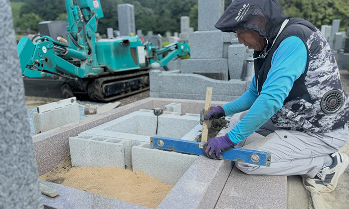 兵庫県宝塚市の霊園で、中国産御影石G６６３の巻石を据えつける弊社の職人