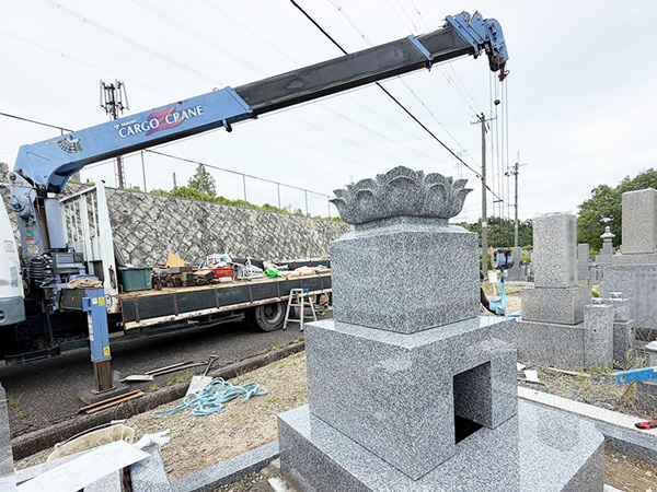 兵庫県宝塚市にて、ユニック車を使用し、天山石の墓石建立工事を行っている写真